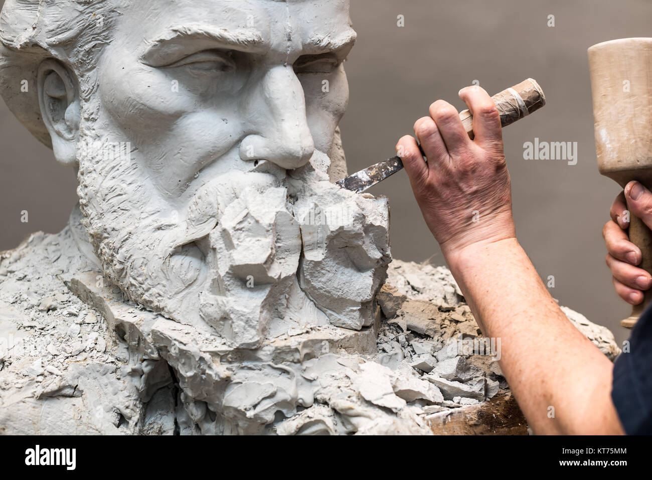 positive-negative-form-hands-of-sculptor-and-hammer-detail-while-carving-KT75MM